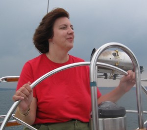 Woman at wheel of sailboat on Lake Ontario
