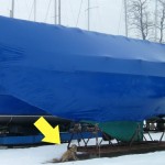Honey the Golden Retriever poses with the keel of a sailboat out of the water.