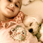 A little girl sleeps with her dog.