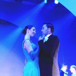 A pair of ballroom dancers pose.