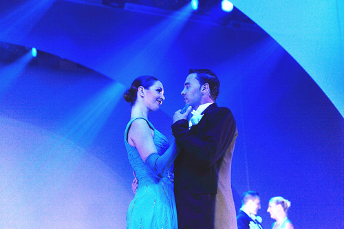 A pair of ballroom dancers pose.