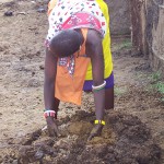 Masai woman repairs her house with dung.