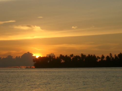 A Guna Yala island in the Caribbean sea at sunset.