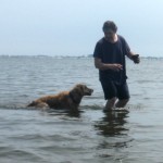 Honey the golden retriever in the water with Mike.