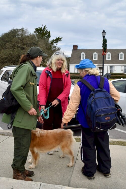 I listen to my dog when she wants to make new friends. [3 Women talking with a golden retriever on a leash.]
