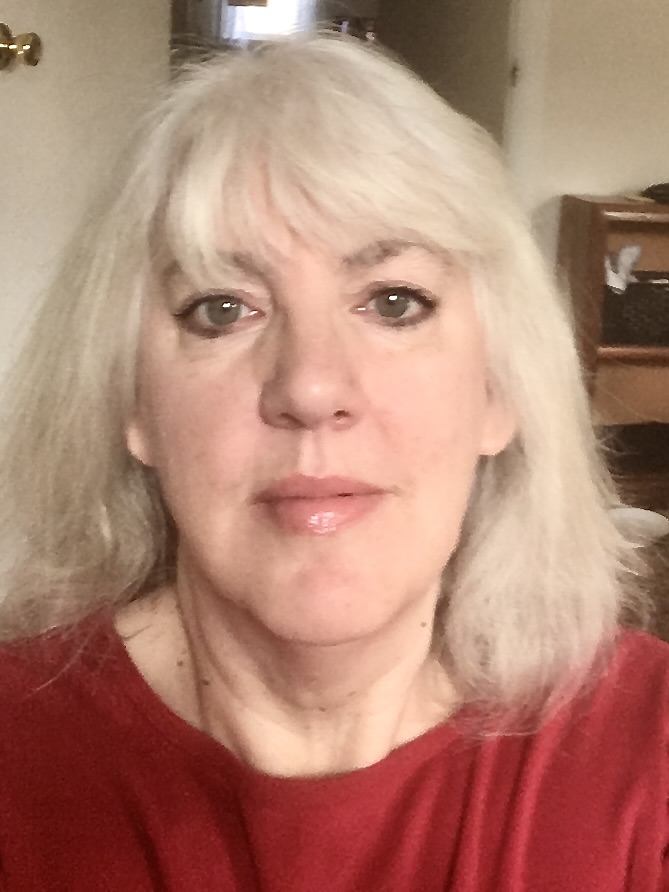 Woman with shoulder length white hair and red shirt